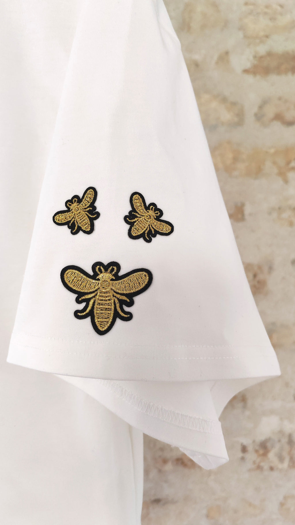Détail écussons abeilles dorés brodés sur t-shirt blanc – BFunny