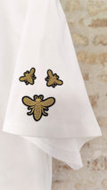 Détail écussons abeilles dorés brodés sur t-shirt blanc – BFunny
