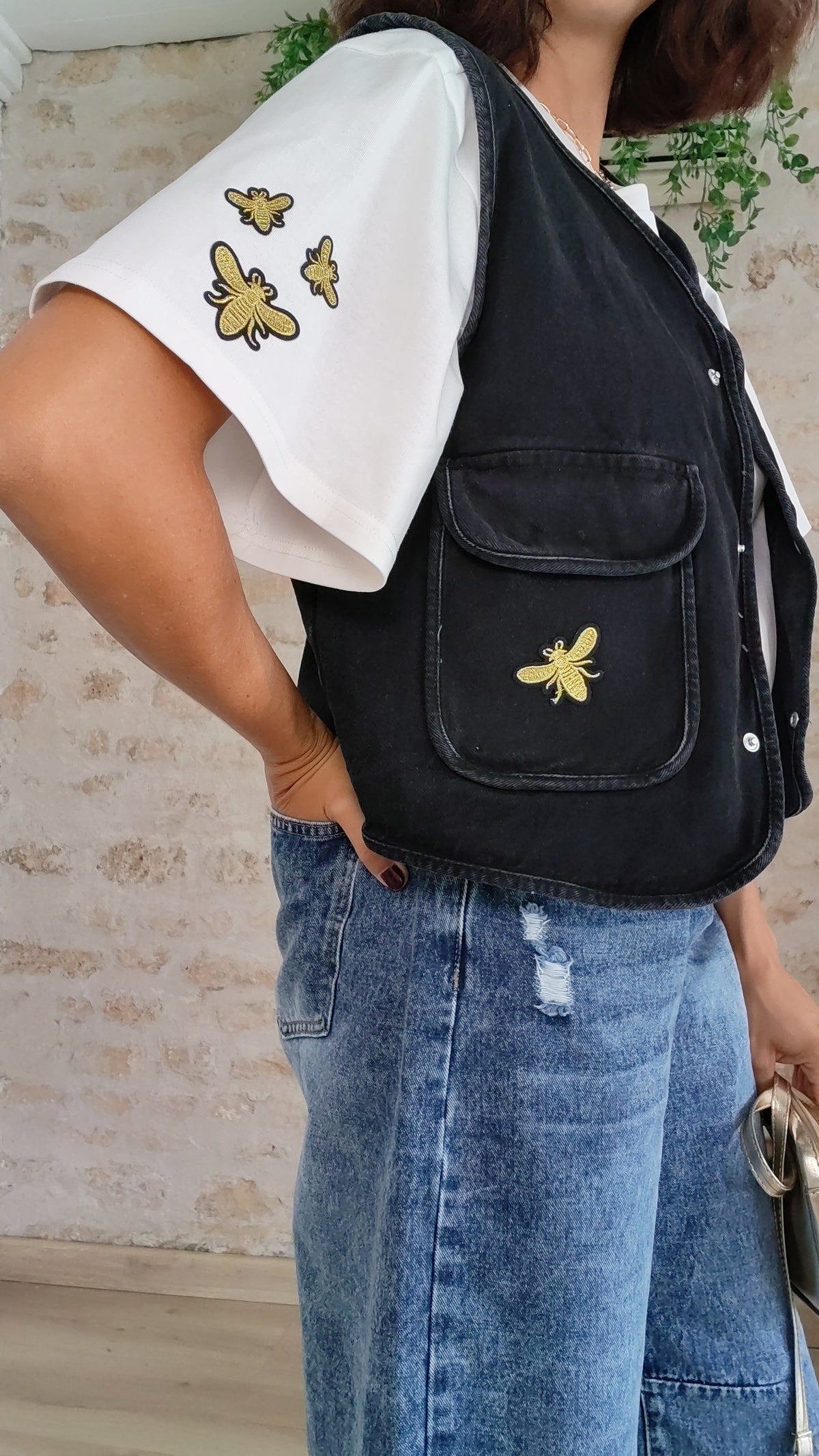 Veste sans manches noire portée avec t-shirt abeille blanc et jean – BFunny