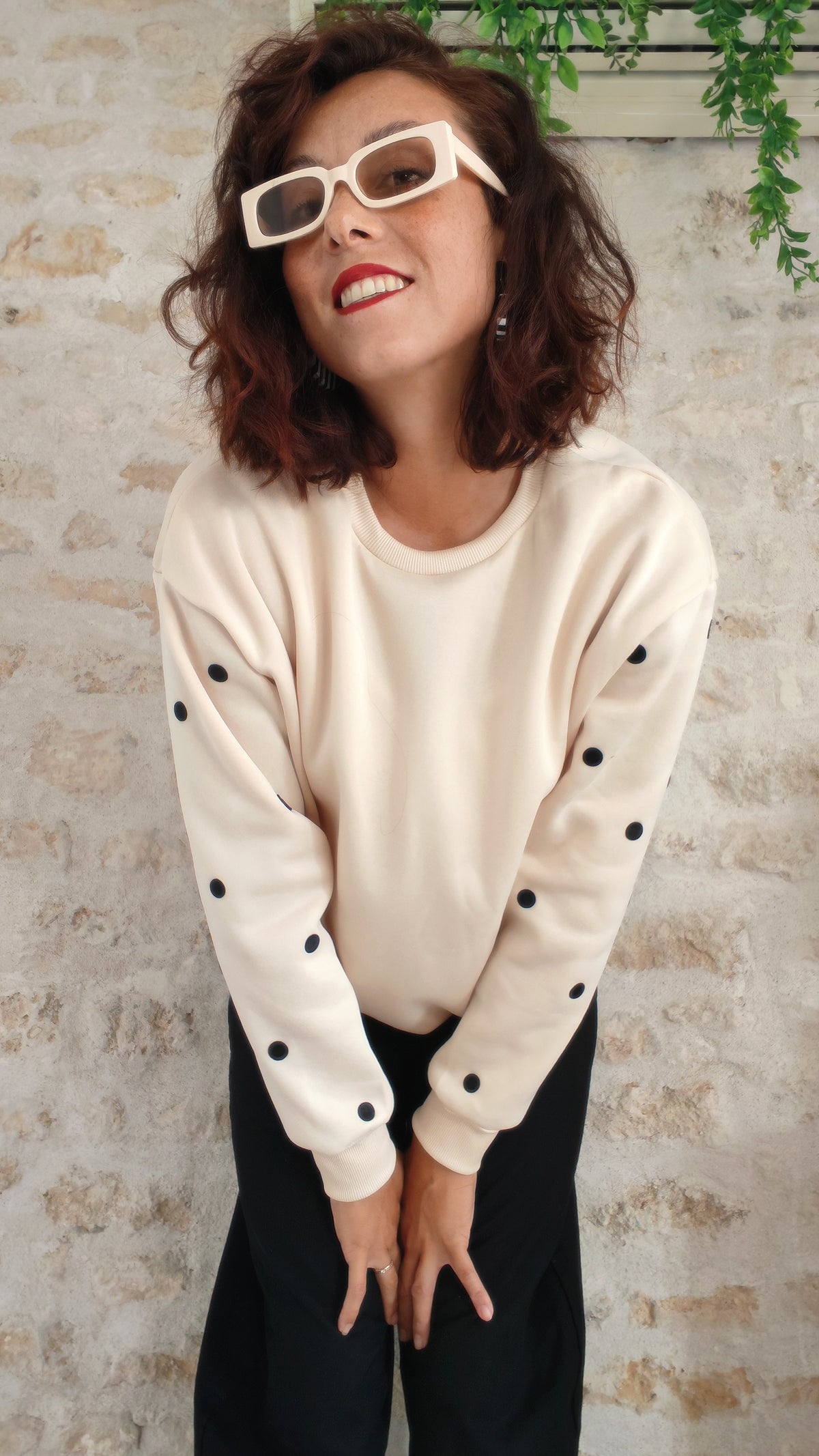 Femme souriante portant le sweat beige pois noirs BFunny, détail des écussons sur les manches